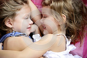 Two twin sisters in a hug, close up