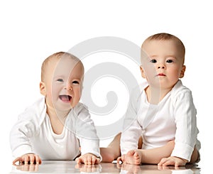 Two twin sisters infant child baby girls toddler sitting in white shirt happy smiling