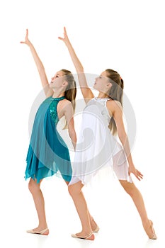 Two Twin Sisters in White and Blue Sport Dresses Dancing Togethe