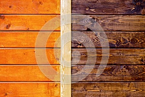 Two types of wooden wall processing: painted orange and treated with brown stain close-up background