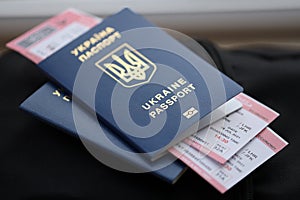 Two ukrainian biometrical passports with air flight tickets on black touristic backpack