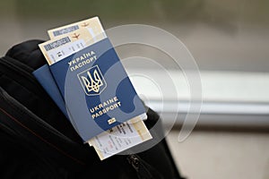 Two ukrainian biometrical passports with air flight tickets on black touristic backpack