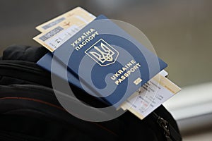 Two ukrainian biometrical passports with air flight tickets on black touristic backpack