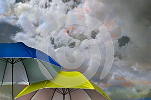 two umbrellas above the white cloudy sky