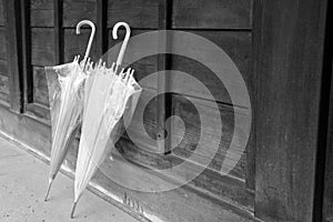 Two umbrellas lean on wood wall