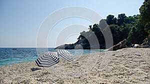 Two umbrellas on a white beach