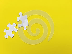 Two unconnected puzzle pieces on coloured background. Problem solving, teamwork and the integration of different elements
