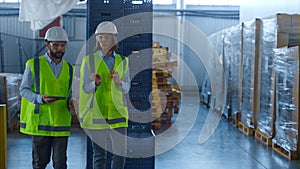 Two uniformed warehouse workers discussing manufacture production inspecting