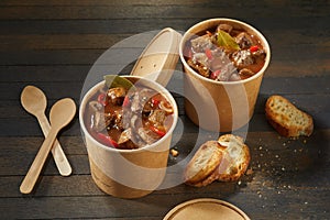 Two unlabelled takeaway tubs of rich beef goulash