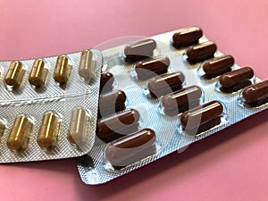Two unopened blisters with multi-colored tablets. preparations of red and brown color. medicines to strengthen the immune system