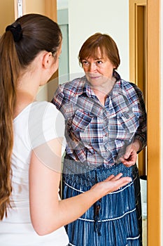 Two unpleased women at doorway