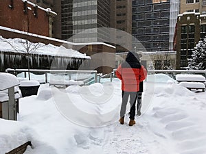 Two unrecognizable people are enjoying Canadian. Heavy snowfall in Calgary, Alberta, Canada