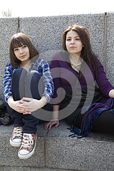 Two urban teen girls sitting on stairs