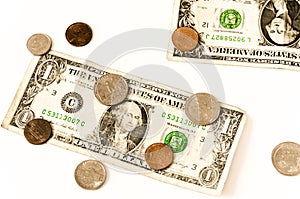 Two usa dollars and coins lay over white