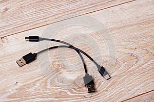 Two USB cables connected on a brown wooden surface