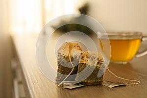 Two used tea bags on wooden table photo