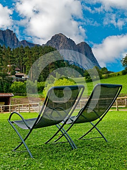 Two vacant deckchairs admiring mountain landscape in summer