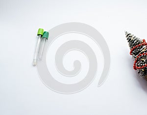 Two vacuum tubes for collection blood samples witn christmas three on white background