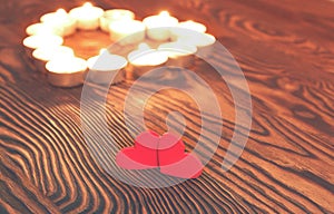 Two hearts, burning candles on wooden. Valentine`s Day.