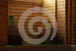 two vases sitting on top of a wooden shelf in front of a wall