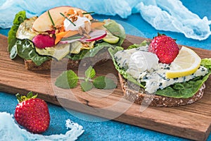 Two vegeterain danish open sandwiches on wooden board