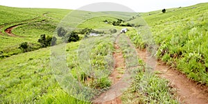 Two Vehicles Traveling on Dirt Track in Mountains