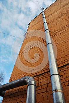 Two ventilation pipes on a brick wall