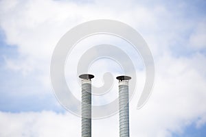Two ventilation pipes over blue sky