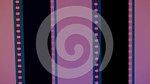 Two vertical film strips on a pink background, close up. 35mm film slide frame. Long, retro film strip frame. Copy space