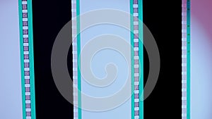 Two vertical film strips on a pink and white gradient background, close up. 35mm film slide frame. Long, retro film