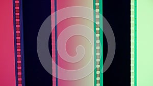 Two vertical film strips on a red and green gradient background, close up. 35mm film slide frame. Long, retro film strip