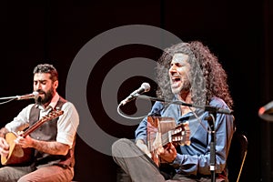 Two very charming musicians playing on a stage