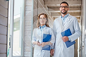 two veterinarians in white coats walking with clipboards in veterinary