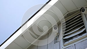 Two video cameras on a neighborhood building roof