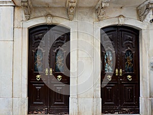 Two vintage double doors decorated with classy art deco ornate outside on the street of Elvas, Portugal