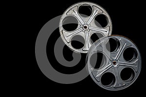 Two vintage film reels on a black background with copy space