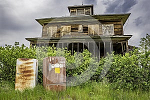 Two vintage fridges abandoned outside an old home on the prairies