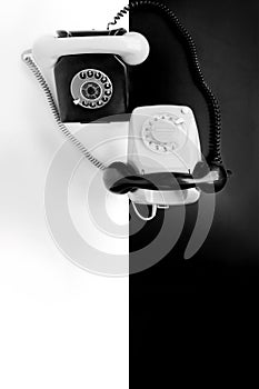 Two vintage telephone sets with dial in retro style on a black, white background, concept of old communication technologies,