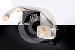 Two vintage telephone sets with dial in retro style on a black, white background, concept of old communication technologies,