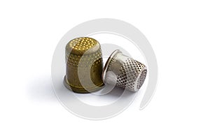 Two vintage thimbles isolated on a white background with shadow.