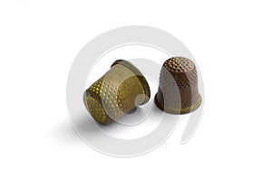 Two vintage thimbles isolated on a white background with shadow.