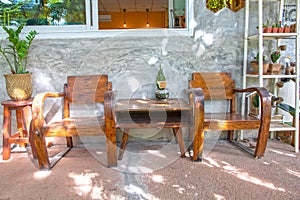 Two vintage wooden chairs on cement porch and polished cement wall front of house