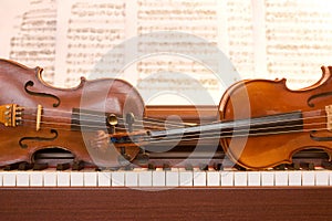 Two violins on piano keys