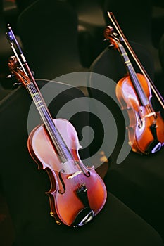 Two violins on some chairs