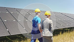 Two walking amid solar cells in a power plant