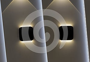 Two wall lights with symmetrical highlights on the wall.