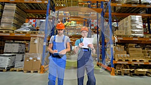 Two warehouse supervisors check the storage capacity.