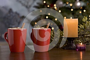 Two warm holiday drinks by the tree.