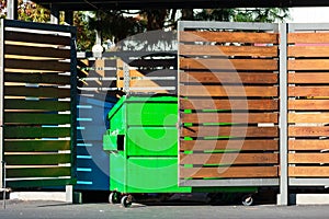 Two waste management blue and green garbage containers dumpsters