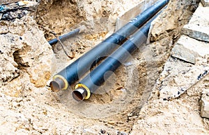 Water pipes in ground pit trench ditch during plumbing under construction repairing